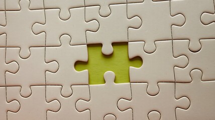 Close-Up of Pale Blue Jigsaw Puzzle with Missing Bright Yellow Piece at Center, Featuring Scattered Pattern on Light Gray Background for a Clean, Modern Aesthetic