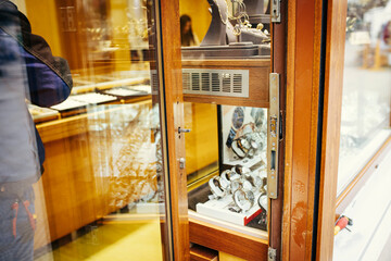 An open jewelry and watch showcase with visible luxury wristwatches and a damaged lock, capturing...