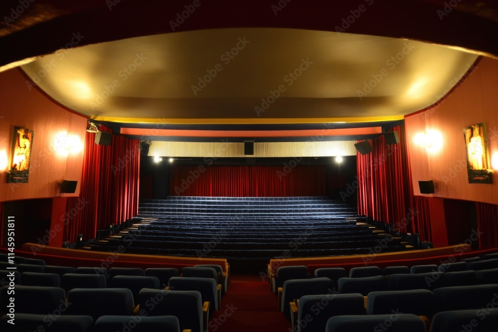 Poster a picture of an empty theater with red curtains and blue seats, ideal for use in scenes where a perf