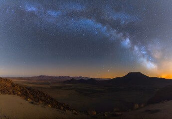 A star-filled sky with majestic mountains at night