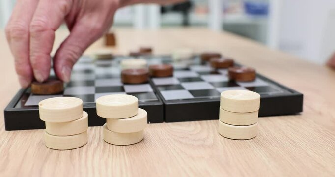Player makes a strategic move in game of checkers and turns over a checker
