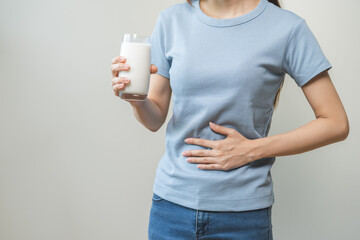 Pain, suffering asian young woman having a stomachache, abdominal pain or digestive, hand in...