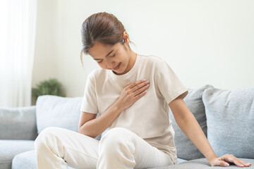 Heart attack, health care concept, suffering acute cardiac asian young woman hand touching on her...