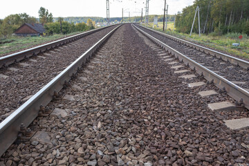 Fototapeta premium Railway in Tula region, Russia. landscape with railway track, sky with clouds, trees and grass. railway junction. travel. nobody. transportation.