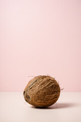 Whole coconut on pink background.
