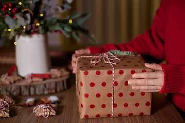 female hands holding Christmas gift box at home, New Year's Eve