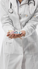 Cropped photo of young medical therapist holding blisters of medical treatments against white studio background. Pharmaceutical. Concept of medicine, health care, work. Ad