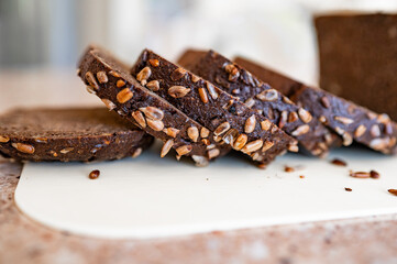 black artisan bread with seeds on a white board
