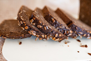 black artisan bread with seeds on a white board