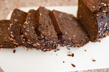 black artisan bread with seeds on a white board