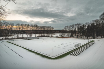 Obraz premium Minimalistic sport area covered in snow, high quality. Sport fields not used in winter. Soccer goal in snow. Winter break. Belgium flanders winter time. 