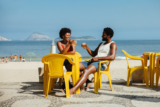 Young couple enjoying a date at a beachside cafe - Powered by Adobe