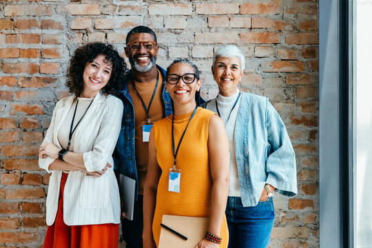 Smiling and confident group of diverse professionals standing together in a welcoming office environment promoting teamwork and collaboration