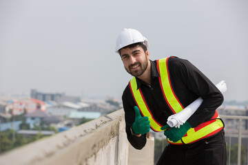 Male foreman builder working at construction site. Male engineer inspecting work at construction site, wearing safety uniform, helmet