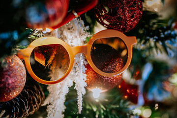  Close-up of a Christmas tree decorated with red ornaments, pinecones, snow-like branches, and...