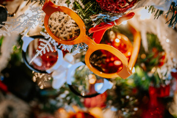  Close-up of a Christmas tree decorated with red ornaments, pinecones, snow-like branches, and...