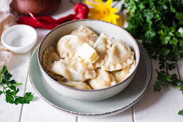 Pork dumplings in a green plate on a white table for lunch. Ravioli with cheese in a green plate. Close-up