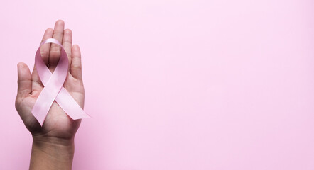 Pink Breast Cancer Awareness Ribbon. Hands holding pink ribbon on backgrounds. Breast cancer awareness and October Pink day, world cancer day. Top view. Mock up.
