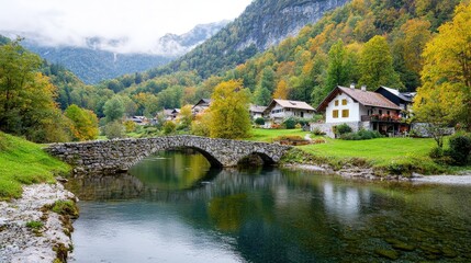 Fototapeta premium Stone bridge over calm river in autumnal mountain village.