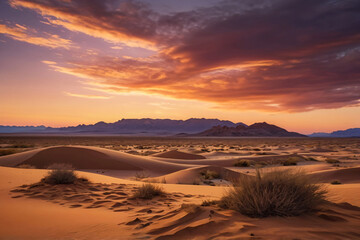 Fototapeta premium A stunning desert landscape at sunset with sand dunes, sparse vegetation, and a distant mountain range under a colorful sky with clouds. The warm light creates dramatic shadows and highlights the text