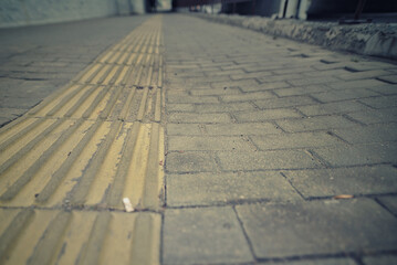 Dented, uneven paving slabs on public walkway, infrastructure flaws and the need for repairs to...