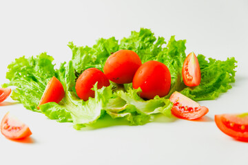 green raw lettuce and slice of tomato pile to make a salad and sandwich isolated on white background