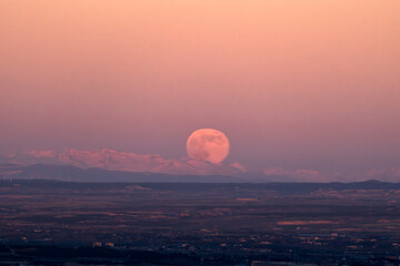 Luna superllena saliendo detrás de montaña