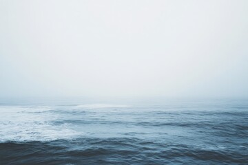 Fototapeta premium The ocean stretches into the distance, its calming blue waves gently rolling under a soft sky, evoking a sense of endless possibility and serene contemplation.