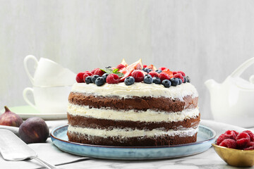 Delicious chocolate sponge cake with berries served on white table