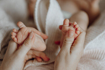 A baby's feet are being held by a person. The baby's feet are pink and have a lot of hair © Vasil