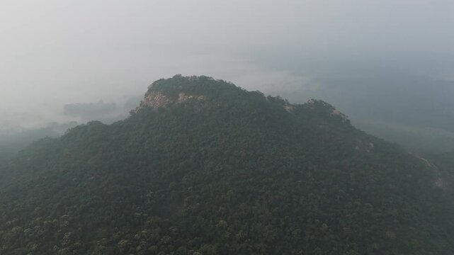 A majestic view of the hilltops and their cascading slopes, covered in rich vegetation. The lushness of Matha Forest contrasts with the rocky outcrops, presenting a perfect harmony of nature.