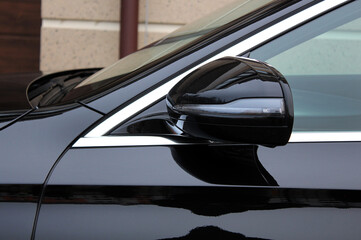 Black rear view mirror of premium car. Luxury black car side mirror. Modern car rear view mirror.