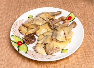 Lung Guang Chicken Whole poached chicken cut with cucumber served in tray dish isolated on wooden table side view of hong kong food
