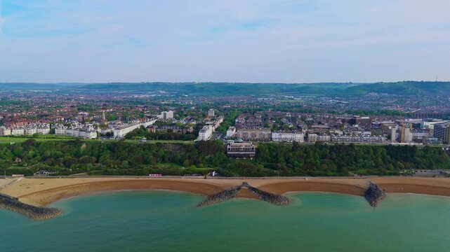 Folkestone shoreline, craggy outliers , golden sand, calm sea water