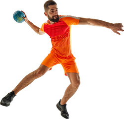 Athletic young bearded man in orange uniform, handball player in motion with ball during match...