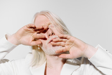 Fototapeta premium portrait, model, fashion, expressive, artistic, white background, serene, emotions, hands, light skin, subtle, style, beauty, soft focus, elegance, contemporary, gesture, intimate moment