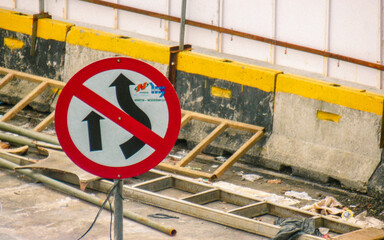 
A no U-turn sign in a construction zone with concrete barriers.