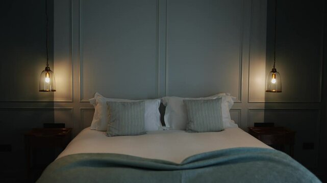 A bed with two pillows and a white sheet. The pillows are striped and the bed is made
