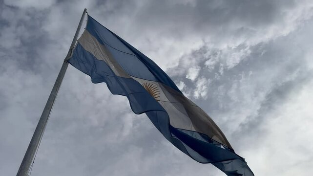 bandera argentina flameando sobre sol, cielo azul	
