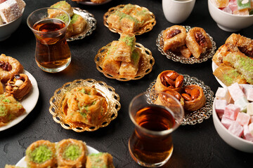 Traditional Middle Eastern sweets and pastries served on plates with tea in a cozy setting