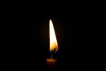 burning candle on black background
