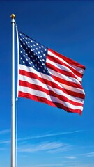 Obraz premium American Flag Waving in the Wind Against a Clear Blue Sky
