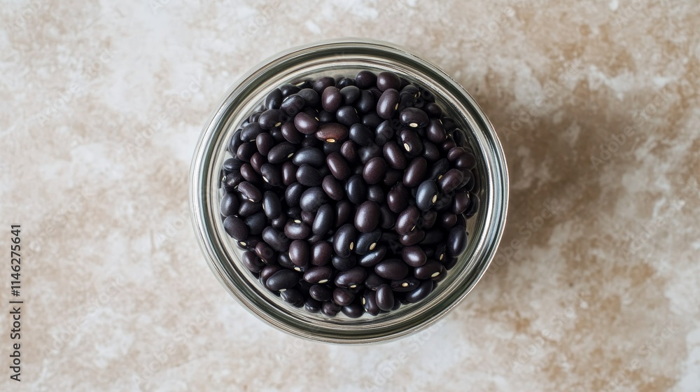Poster top view photo of a glass jar filled with black beans, showcasing the texture and color of the black