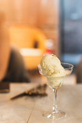 Glass with delicious vanilla ice cream on table.