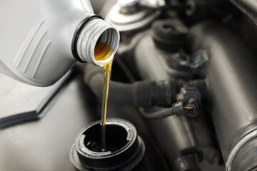 Pouring motor oil into car engine, closeup