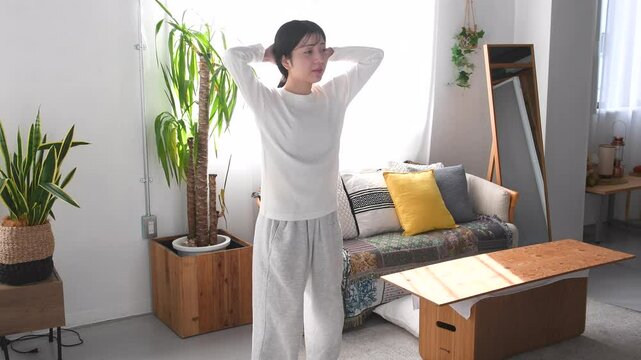 自宅で自重の筋トレ（スクワット）する女性