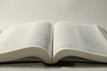 Open Holy Bible in English language on white table, closeup
