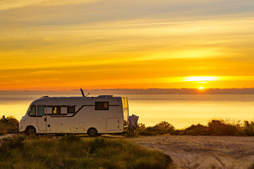 Caravan on sea at sunrise.