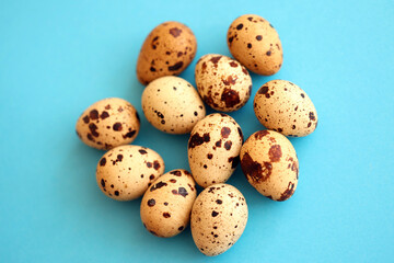 Obraz premium Few amount of quail eggs in small pile on blue background