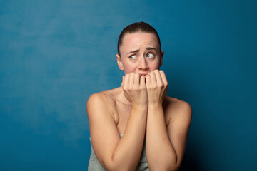 looking worried, anxious, stressed and afraid, biting fingernails and looking to lateral copy space